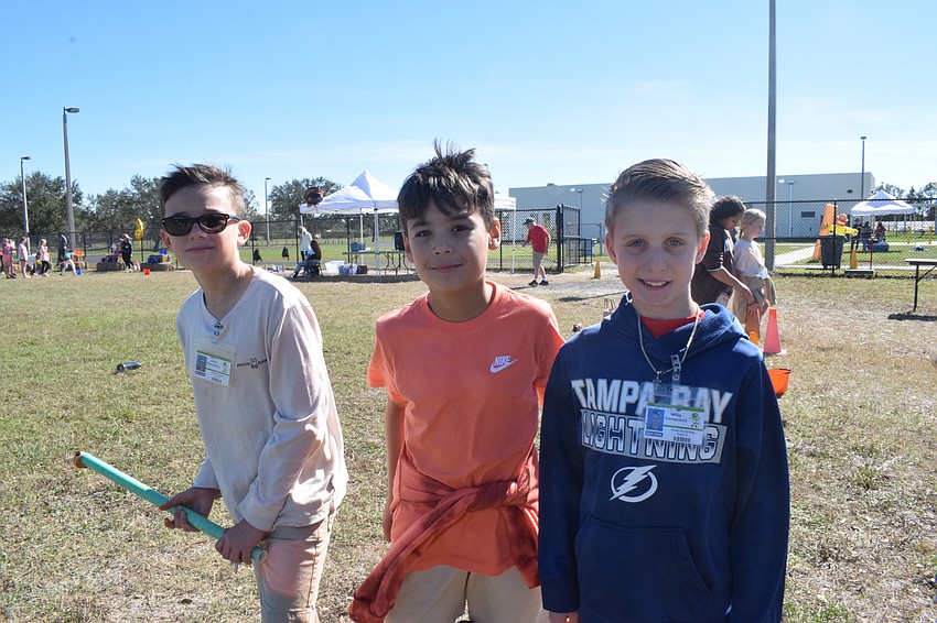 Fifth graders Graham Lough, Ethan Byal and Noah Shortridge cheer for each other while participating in the fishing station.
