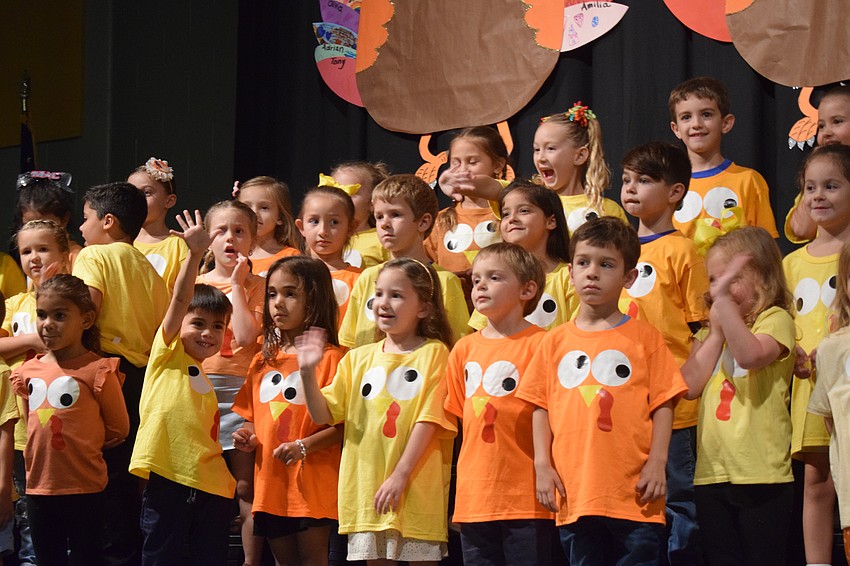 Kindergartners wave to their families in the audience as they take the stage.