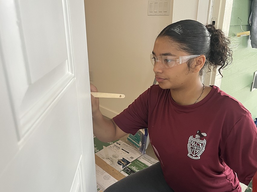 Sophomore Mystique Quinones takes her time painting the front door to ensure it's well done.