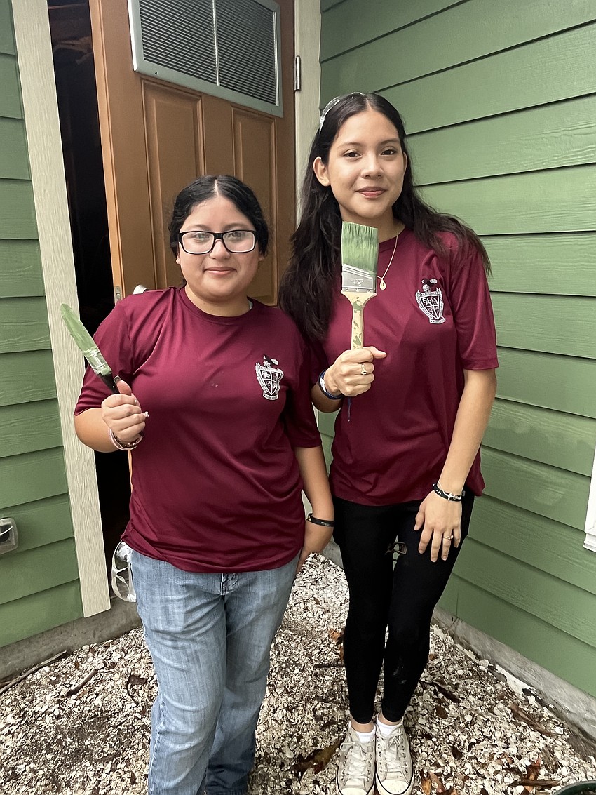 Seniors Meyli Rojas and Val Amezquita paint the back exterior of the home. The service project was a bonding experience for the cadets.