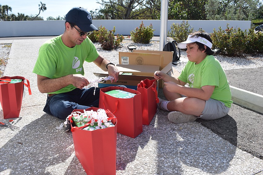 John Paul Dean and Carlos De Armendi putting together gift bags for the Longboat Key Fire Rescue.