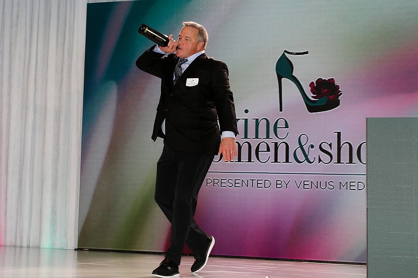 The Butcher's Block own Scott McGowan on stage shows a way to enjoy the wine donation.