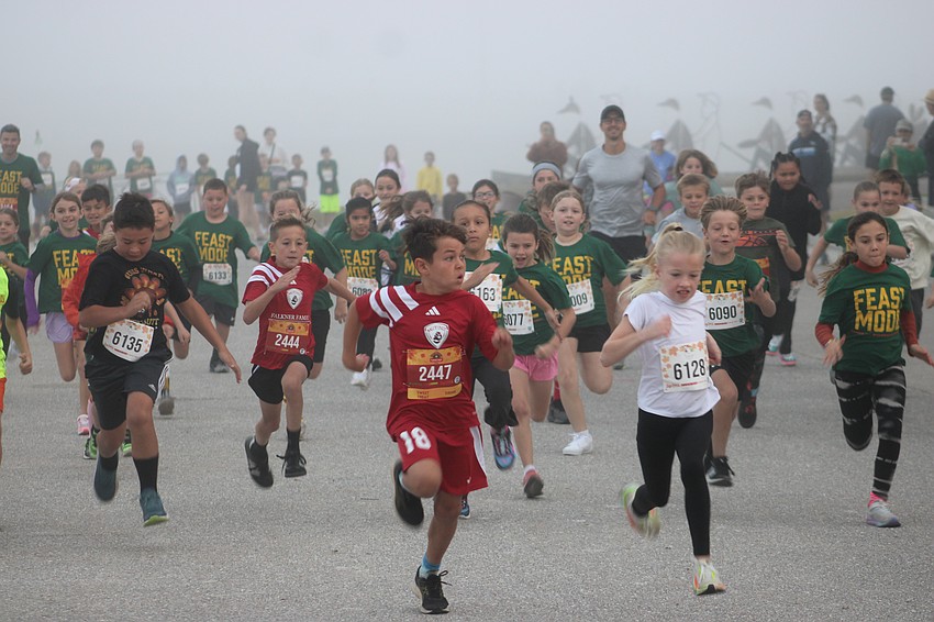 The runners come out of the fog during the kids run of the 2024 Florida Turkey Trot at Nathan Benderson Park.