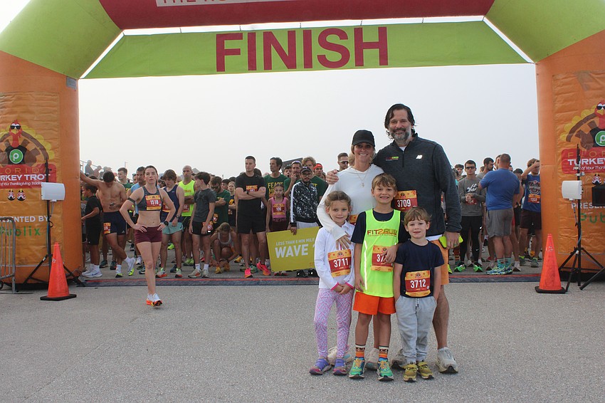 Kate and Parks Robinson stand behind their kids Genevieve, 6, Parks, 8, and Blaise, 4, as the family was about to run the Florida Turkey Trot together. The run benefits the Big Bill Foundation to honor Parks' father.