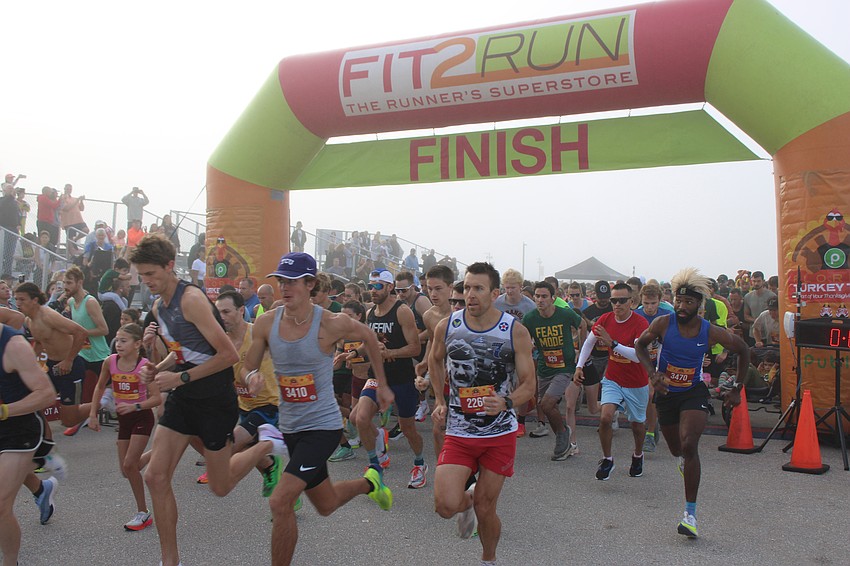 Runners break from the starting line in the fog to begin the 2024 Florida Turkey Trot at Nathan Benderson Park.