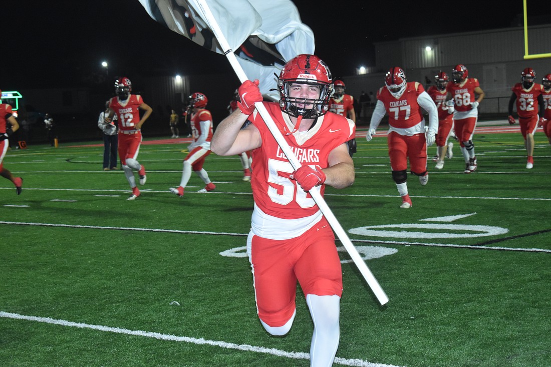 Cardinal Mooney junior defensive lineman Konnor Whitesell leads his team prior to Cardinal Mooney's regional final bout with Bishop Verot.