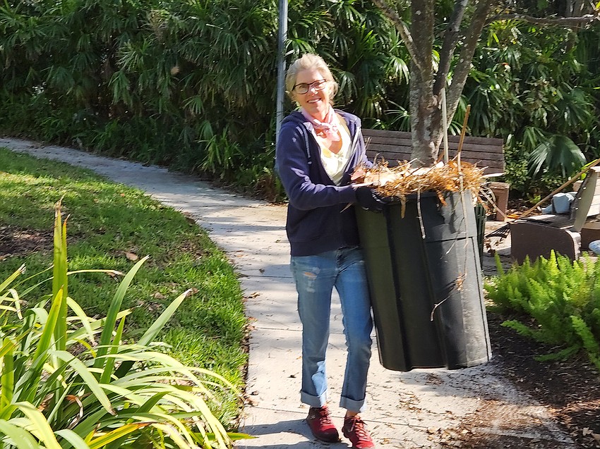 Laurel Park Sadie Laughlin hauls a trash can of debris from the back of the park to the front of the park on Saturday, Nov. 30.