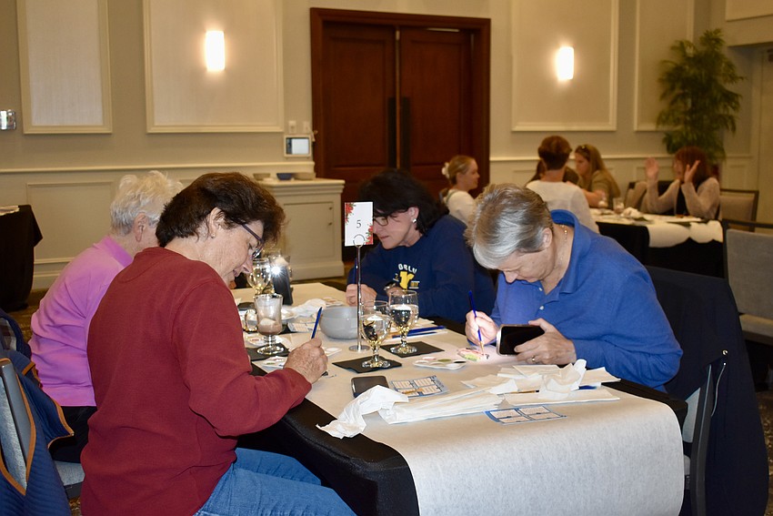 Sarasota's Pam Shoosmith is on the left with her mom Lilyan Shoosmith, and Lakewood Ranch's Julie Stephenson and Pam Hazelwood are on the right. The friends are using the lights on their phones to make their painting more precise.