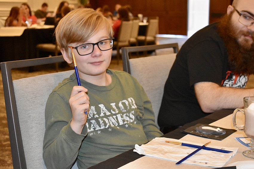 Bradenton's Noah Hamper, 9, is painting a penguin ornament.