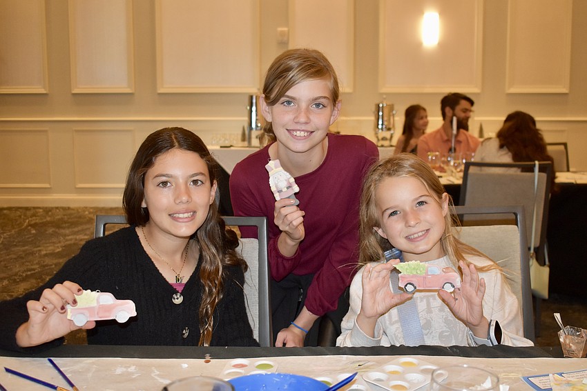 Rhea Krolik, Autumn Bryan and Mila Hoort show off their freshly painted Christmas ornaments.