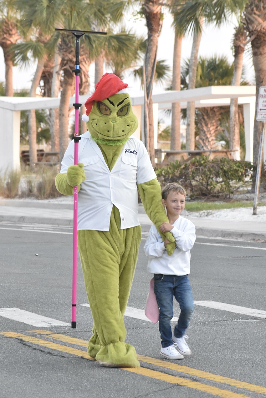 Jason Harless, who co-owns the local branch of Pink's Window Services with his wife Tori Harless, walks with his son Tristan Harless, 5. His daughter Isla Harless, 3, was also in the parade.