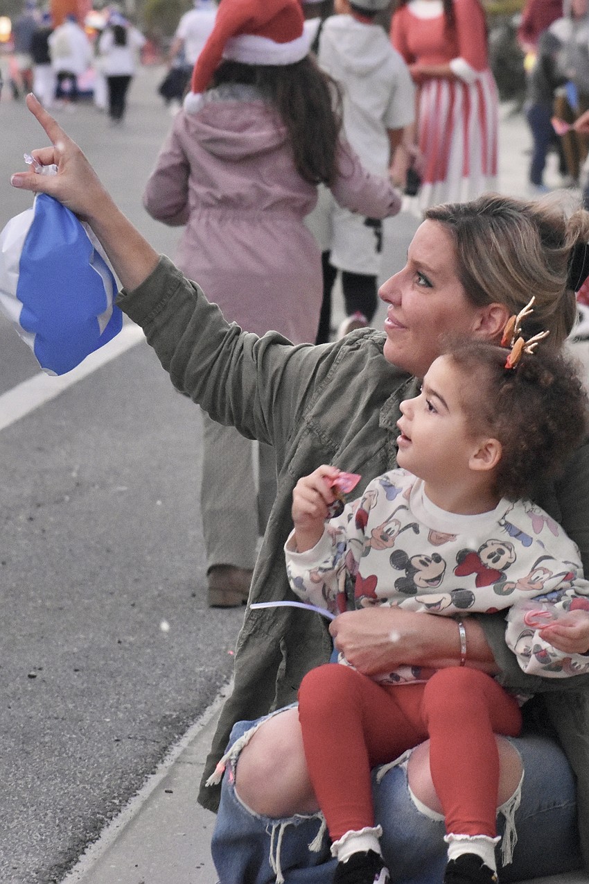 Donna Simon and Sienna Simon, 2, watch as a flurry of snow comes down from the Air Force One float.