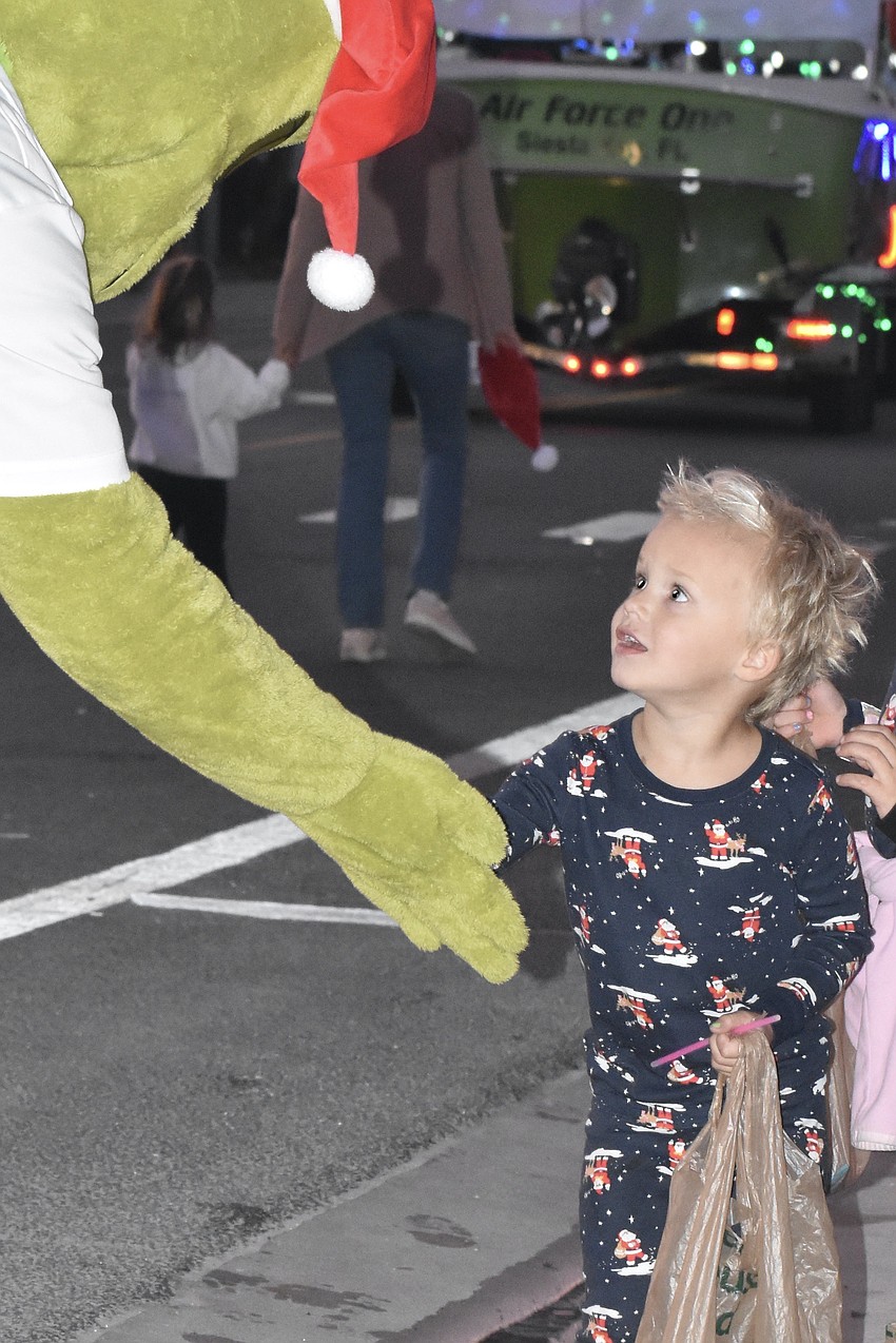 Leo Hopen, 3, accepts candy from Jason Harless of Pink's Window Services.