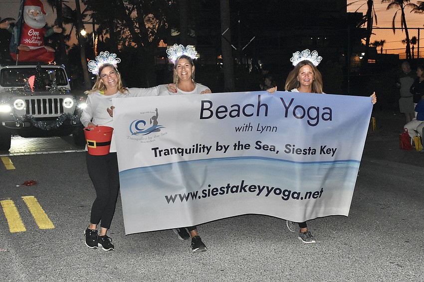 Lynn Hagan, Jody Mack and Cindy Burke-McGuire carry the Tranquility by the Sea banner.