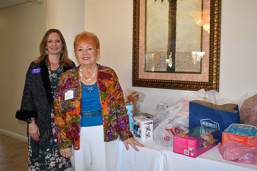 Melissa Ferlazzo, philanthropy officer at Safe Place and Rape Crisis Center, stands with Carolann Garafola, who chairs the club's charity committee. Members brought unwrapped toys to the luncheon for SPARCC's holiday store, where clients shop for free.