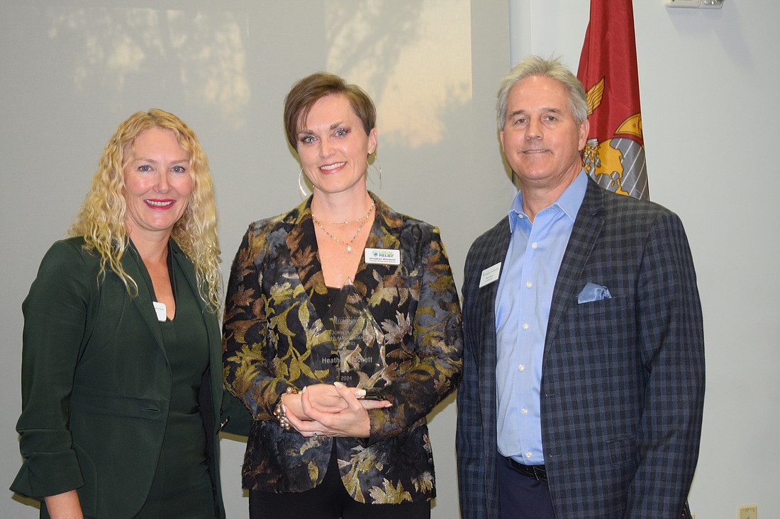 Lakewood Ranch Community Foundation Executive Director Kate Mulligan (left) and President Mark Clark (right) present Heather Hackett with the C. John A. Clarke Humanitarian of the Year award.