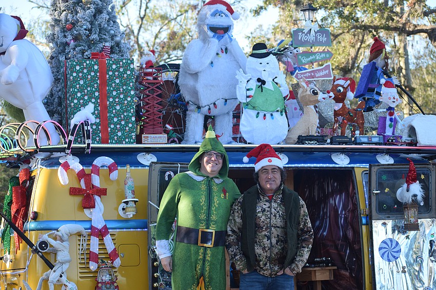 Eric Boyd (left) and Chuck Casagrande pose by Casagrande's van outfitted with tons of holiday decorations, including a functioning model train that ran along the roof.