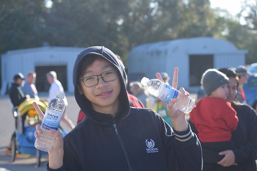 Julian Nguyen was on hand to deliver water bottles as runners crossed the finish line on Saturday morning at the Jingle Jog 5K hosted by The Haven of Sarasota.
