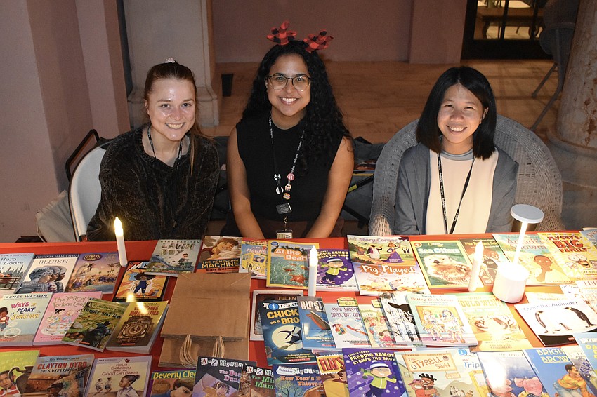 The Ringling Museum's Phoebe Scheidegger, Perez Oliveras and Hsuan Chi Liu staffed a table offering free children's books.