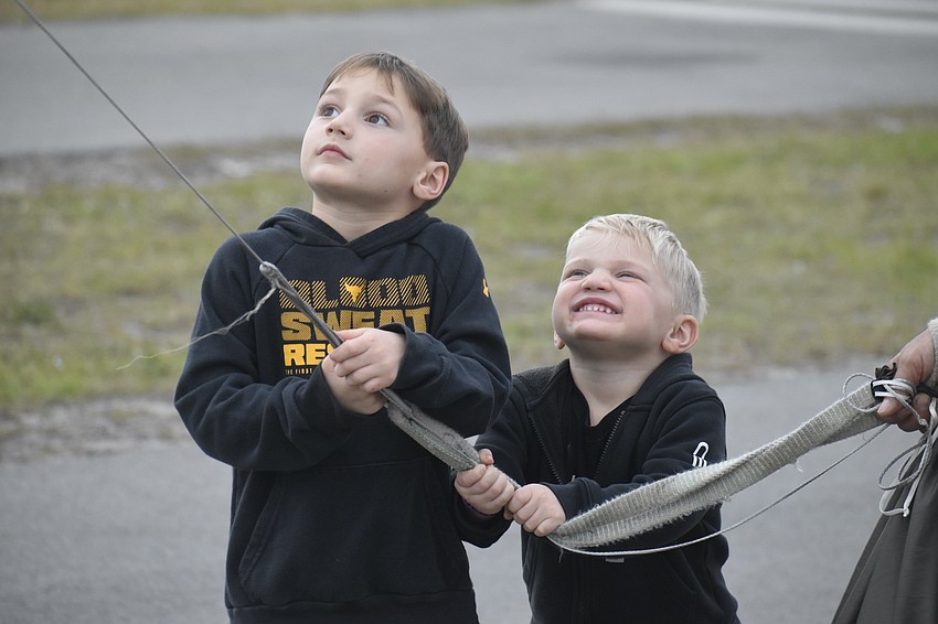 Klay Kotecki, 5 and Dax Kotecki, 3, visitors to the area from Michigan, try their hand at flying a kite.