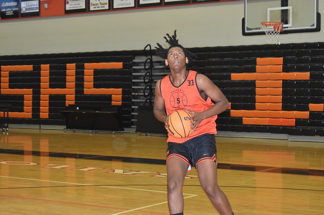 Junior forward David Young rises up for a layup during the Sarasota High boys varsity basketball practice on Dec. 3.