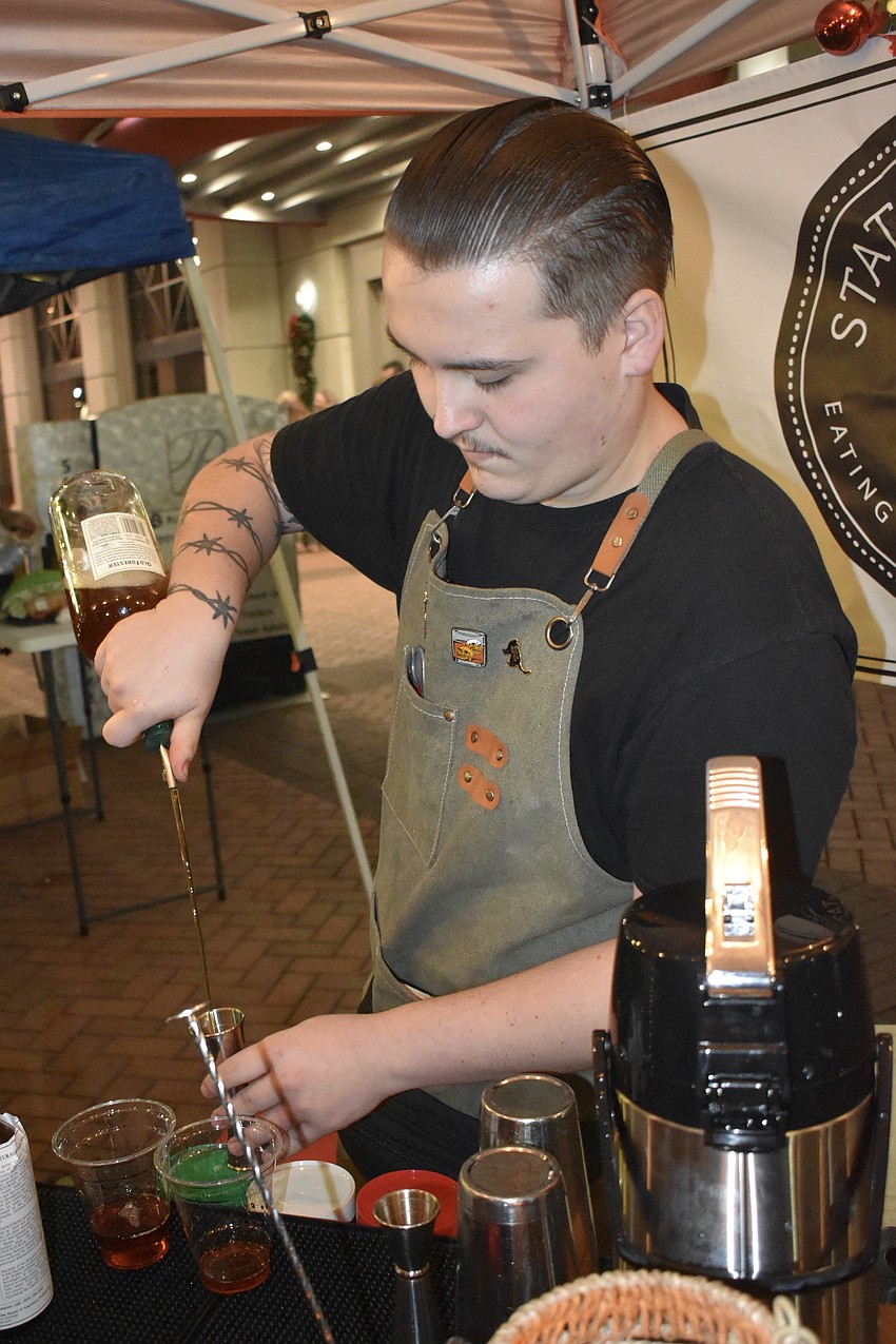 Michael Johnson pours a drink at the State Street Eating House + Cocktails booth.