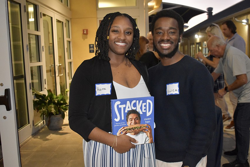 Kiarra Womack and Andre McClerklin pick up a copy of Owen Han's book. Womack remembers Han as sweet and hilarious.