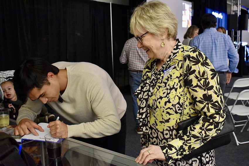 Owen Han signs a copy of his new book for Marjorie Floyd.