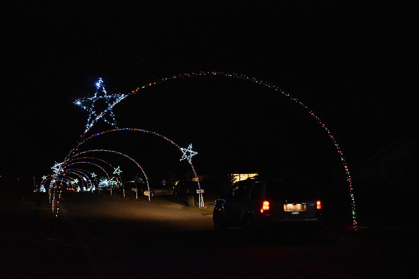 A car drives through archways along a road in Colonial Oaks.