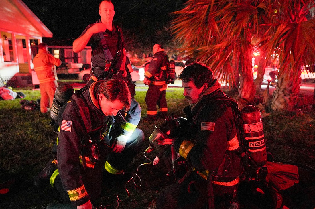 Ormond Beach Firefighters Cannon Tarnow and Garrett Fiske help a dog on the scene of the fire on Roosevelt Drive. Photo courtesy of the Ormond Beach Fire Department/Pauline Dulang