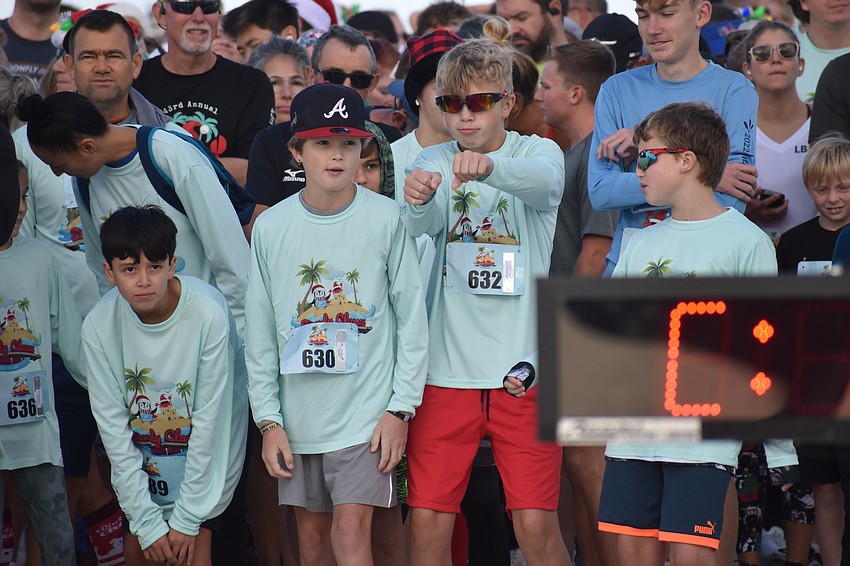 P. Gomez, 12, K. Masse, 12, Ryan Masse, 14 and J. Masse, 10 await the start of the 5K, as Ryan Masse grooves to the holiday music.