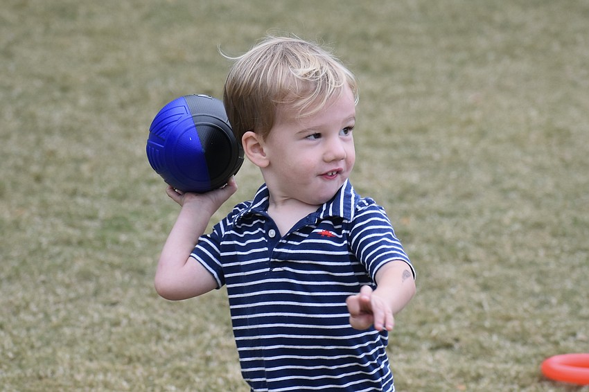 Parker Holmes, 2, prepares to throw a football to his father Dann Holmes.