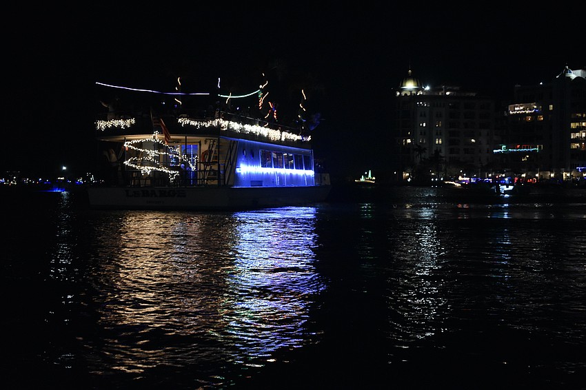 The holiday lights on LeBarge Tropical Cruises mix with the city lights.