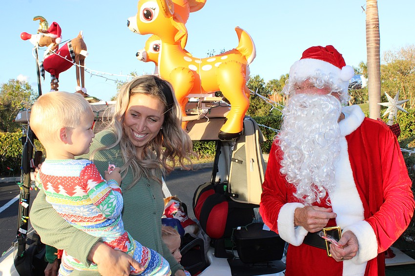 Two-yeear-old Wells Whitehead and his mom Aston Whitehead visit with Santa before the Tara Holiday Golf Cart Parade Dec. 13.