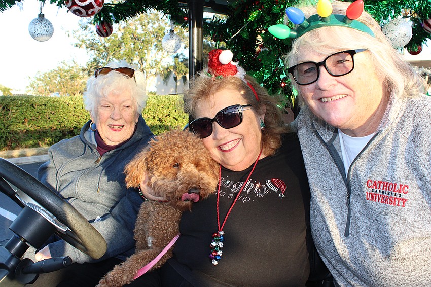 Jeanne Smith, Ruby the dog, Sharon Viner and Nora Lissy are ready to start the Tara Holiday Golf Cart Parade.