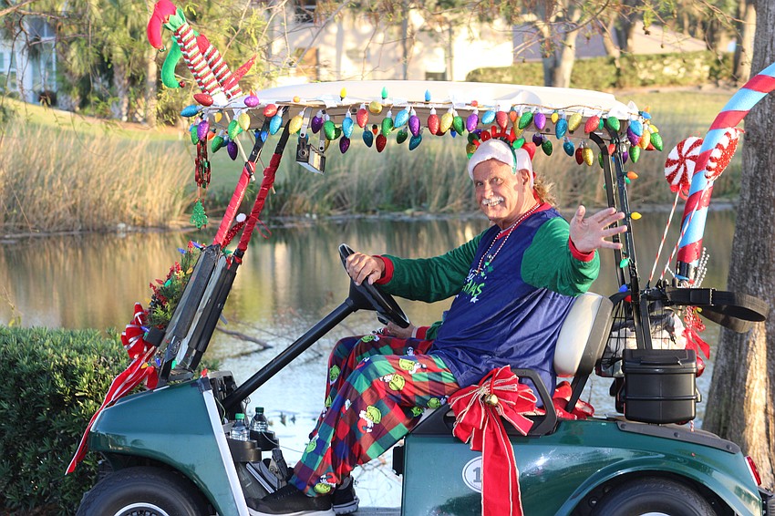 Tony Palmeri uses his parade wave during the Tara Holiday Golf Cart Parade.