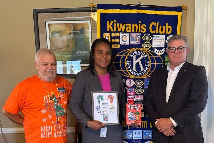 Flagler Schools Superintendent LaShakia Moore receives the Flagler Palm Coast Kiwanis Club's Legacy Book Award from the club's president, Ed Pruitt (right), and past president, Warren Mudd. Courtesy photo