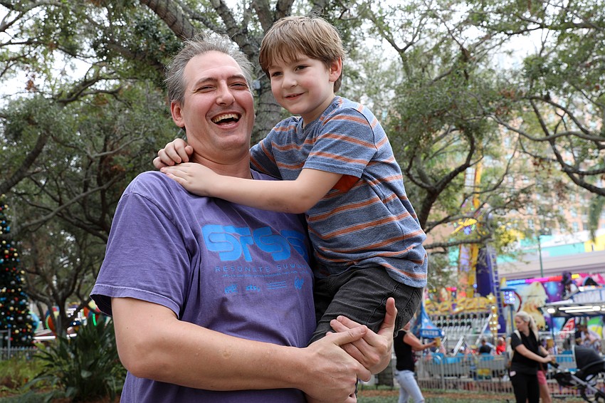 Isaac Skinner is all smiles as he gives his dad, Neil, a hug after a successful ride down the Super Slide on New Year's Eve.