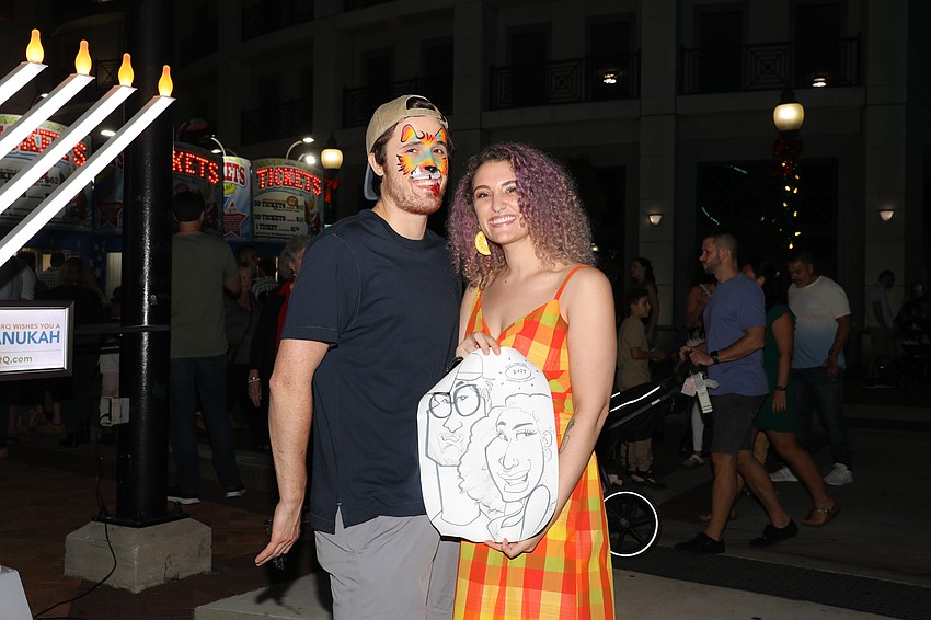 Nicholas Capri and Jess Osher show off their new caricature drawing.