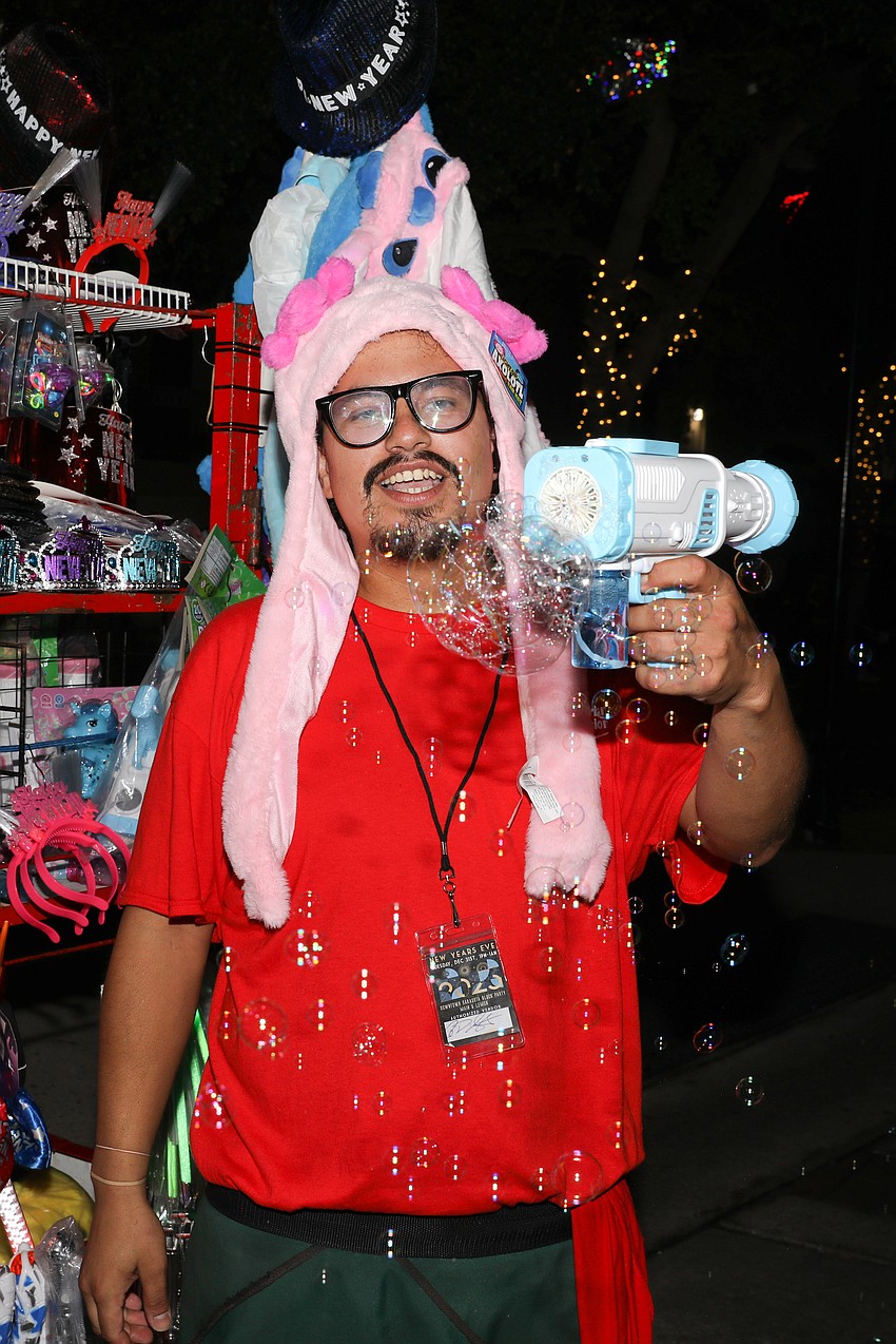 Bubble supplier Berto Rodriguez enjoys watching people chase his bubbles during the New Year's Eve celebration in downtown Sarasota.