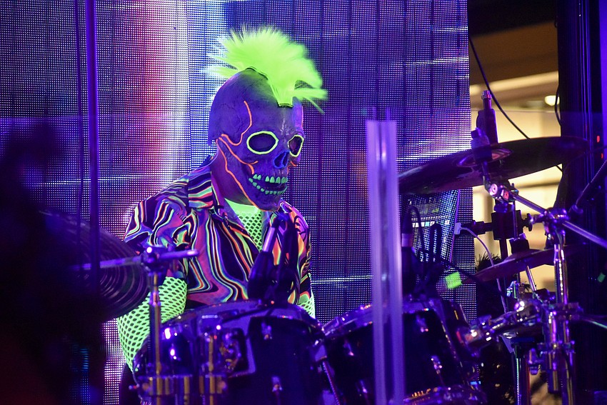 The drummer's neon mohawk commands attention from the back of the stage.