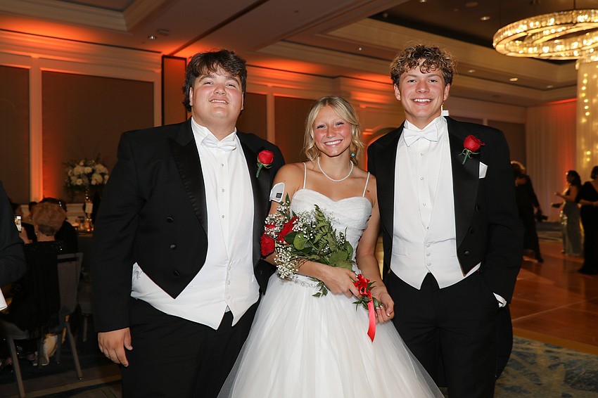 Debutante Rylie Jackson is escorted by Thomas Parker and Andrew Duffy.