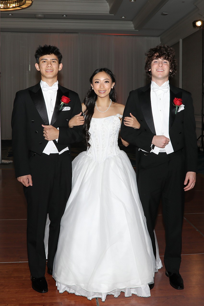 Debutante Mischa Doan is escorted by Beaumont Smith and Porter Douglas.