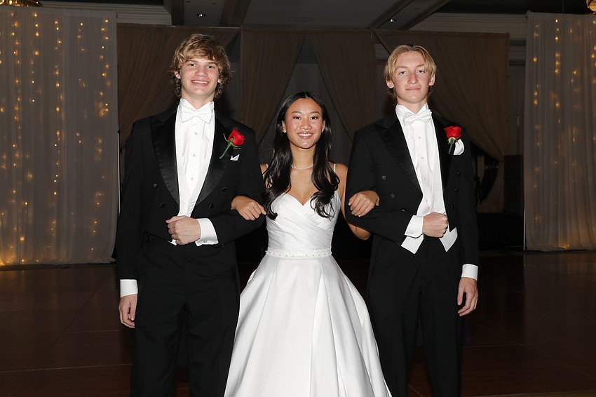 Debutante Roselynn Wagner is escorted by Matthew Morris and Jake Hoddinott