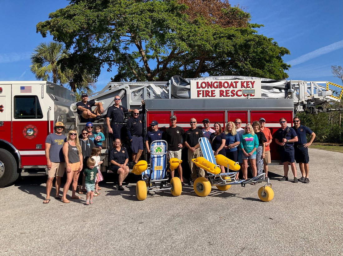 Members of Flanigan's family with the Longboat Key Fire Rescue Department when the family delivered the beach wheelchairs in honor of Jean Flanigan.