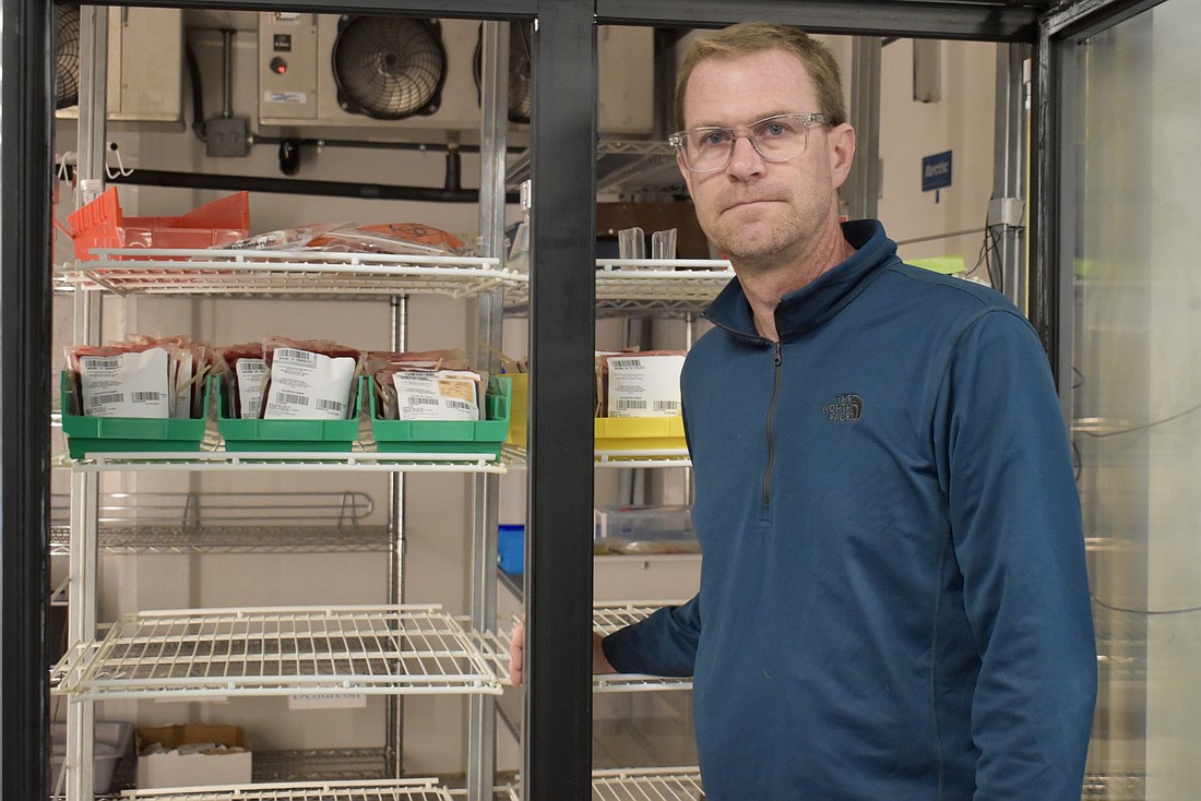 Brian Dryfhout, director of marketing and communications for SunCoast Blood Centers, stands in front of the nearly empty cooler at the Lakewood Ranch location. SunCoast is asking the community for donations due to a shortage of blood.