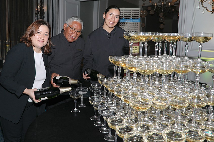Ritz-Carlton staff Remmie Czerpak, Leonardo Ayala and Maria Adarmes build a Champagne tower.