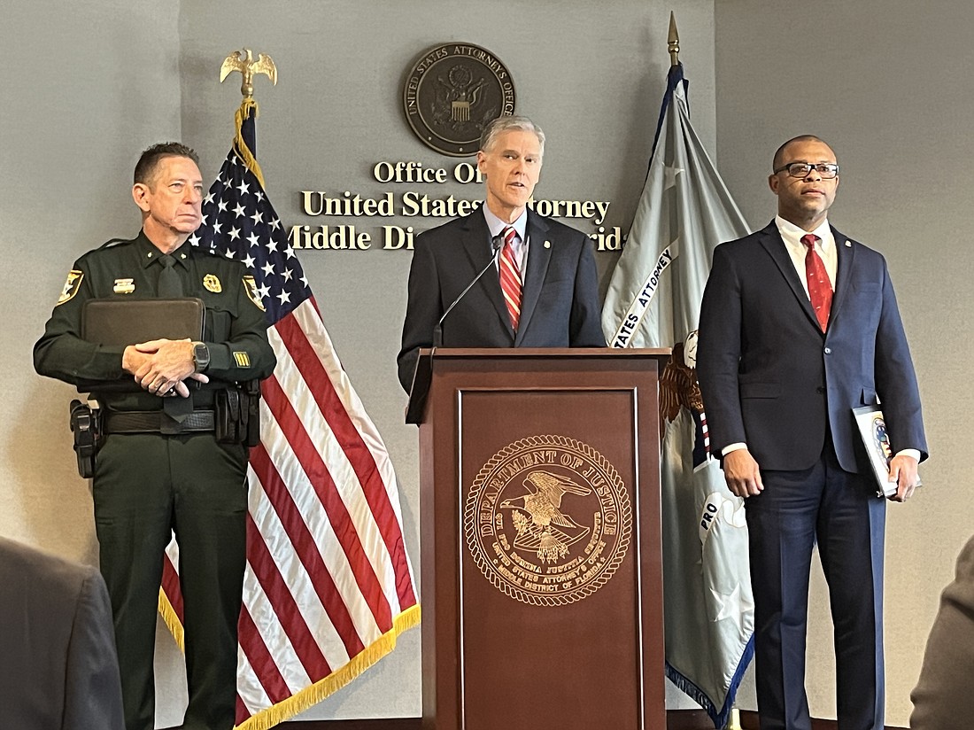 United States Attorney Roger B. Handberg speaks at a press conference in Tampa alongside Sarasota County Sheriff Kurt Hoffman (L) and FBI Supervisory Special Agent Alvin Lewis (R).