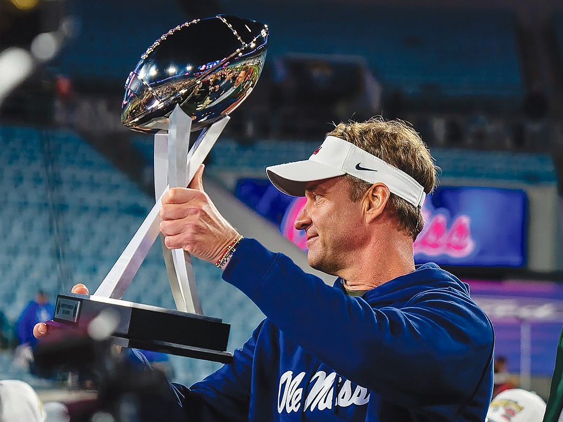 Ole Miss head coach Lane Kiffin hoists the trophy after his Rebels defeated the Duke Blue Devils 52-20 in the TaxSlayer Gator Bowl on Jan. 2 at EverBank Stadium.