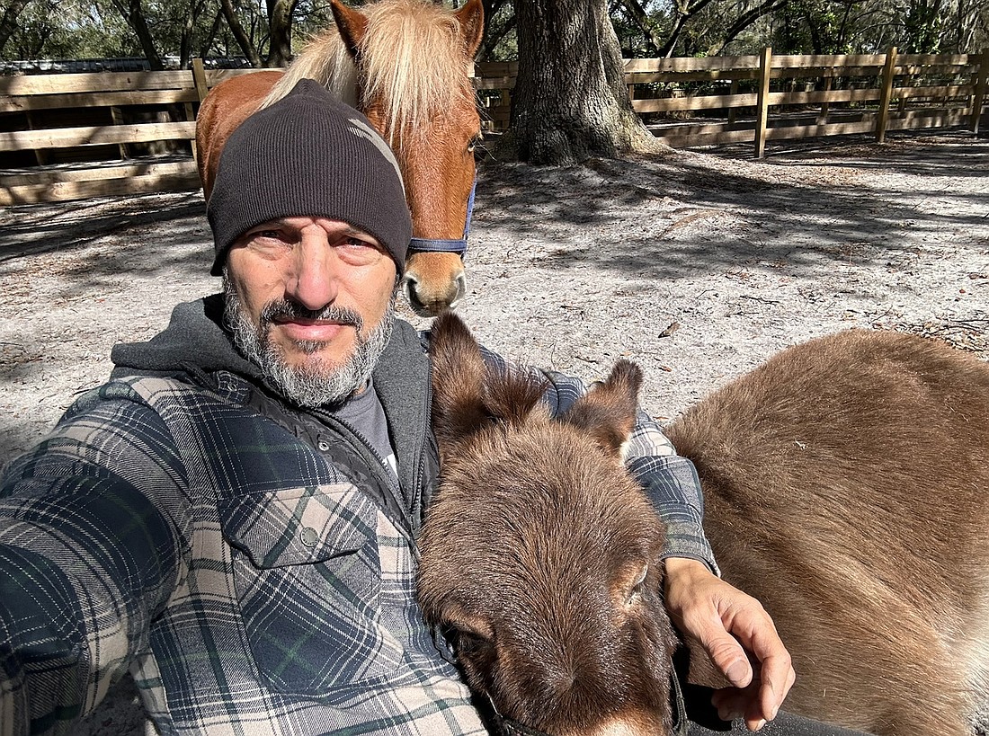 Lee Karlins, the president of Caledon Concepts, poses for a selfie with his donkey.